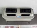 A dashboard air vent of a 2010 Ford Econoline with two adjustable vents and a blue label above the vents
