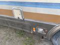 1987 Chevrolet Fleetwood Pace Arrow RV with a brown and blue striped design visible on the side and rear fender showing wear and tear on the surface