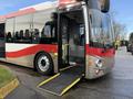 A 2016 Grande West Vicinity bus with a red and silver exterior displaying an open front door and a deployed wheelchair ramp