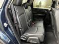 The interior of a 2013 Dodge Journey showing the back seat with black leather upholstery and seat belts attached