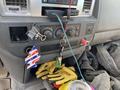 The interior dashboard of a 2009 Dodge Ram 5500 featuring controls for climate and audio along with various items like keys and gloves hanging from it