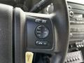 Close-up of the steering wheel controls in a 2016 Ford F-550 featuring buttons for media, volume, seek, and a confirmation button