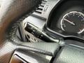 Close-up of a black steering wheel with a gear shift lever and dashboard dials in a 2021 Toyota 4Runner
