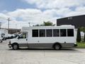 A 2020 Chevrolet Express large white shuttle bus with windows on the side and a gray lower panel