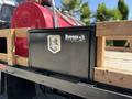 A black tool box labeled Buyers mounted on a wooden truck bed of a 2019 Ford F-350 SD