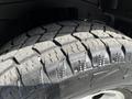 Close-up of a rugged tire with deep treads designed for all-terrain performance on a 2003 Mitsubishi Delica
