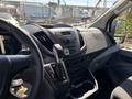 Interior view of a 2016 Ford Transit showing the dashboard controls gear shifter and steering wheel