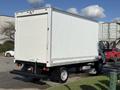 A white 2014 Hino 195 box truck with a plain rear design and a step bumper is parked, showcasing its straightforward and utilitarian appearance