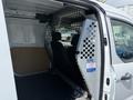 Interior of a 2021 Ford Transit Connect showing a partition with a mesh barrier separating the front seats from the cargo area