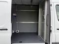 A 2023 Mercedes-Benz Sprinter with an open rear cargo area featuring a flat floor and metal walls
