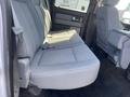 A gray fabric back seat of a 2012 Ford F-150 with textured upholstery and a folding armrest