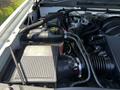 Close-up of the engine compartment of a 2016 GMC Sierra 1500 showcasing the air intake system and coolant reservoir
