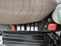 Close-up of the control panel and seat mechanisms of a 2012 Volvo VNL featuring several switches and a label indicating features and functions of the seat
