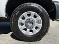 Close-up of a silver alloy wheel with a chrome center cap and all-terrain tire featuring a treads pattern on a 2014 Ford F-250 SD