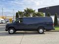 A blue 2011 Ford Econoline van is parked with its side facing the viewer showcasing its sliding door and large body design