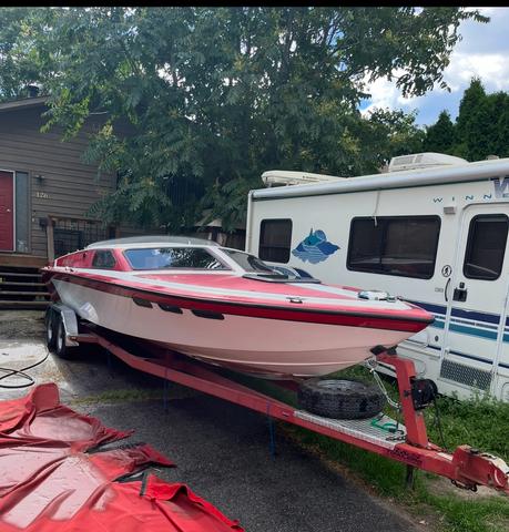 A 1989 Nordic Viking speedboat with a sleek white and red design is mounted on a red trailer, showcasing its sporty and dynamic build