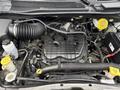 Engine compartment of a 2017 Dodge Grand Caravan featuring various components like hoses and reservoirs