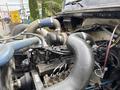 Close-up of a 1998 Freightliner FL80 engine showcasing various hoses wires and components with intricate details of the engine block and turbocharger