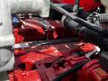 Close-up of the engine compartment of a 2022 Blue Bird BB Conventional showing various red and black components and wiring