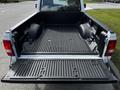 A 2010 Ford Ranger with an empty truck bed showing a textured liner and rear tailgate open