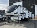 A 2021 Grand Design Reflection 311BHS recreational vehicle with a sleek exterior design and multiple entry points parked in a lot
