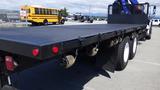 A 2017 Freightliner M2 106 flatbed truck with a black bed and visible tie-down hooks along the side