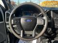 A close-up view of the steering wheel of a 2018 Ford F-550 with a Ford logo and various controls on the wheel