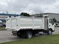 A 2014 Hino 195 truck with a white dump body parked and facing left showing its compact design and rear storage area