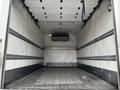 Interior of a 2018 Isuzu NRR truck with a spacious cargo area featuring metal tracks along the walls and a ceiling-mounted air conditioning unit