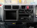 Dashboard of a 2001 Toyota Dyna featuring control knobs buttons a digital clock and an empty storage compartment