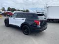 A 2021 Ford Explorer in black and white with a sleek design and black wheels parked at an angle showing its rear and side features