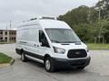 A white 2017 Ford Transit van with a black grille and side stripe is parked with a refrigeration unit on top