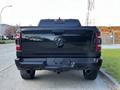 Black 2019 RAM 1500 pickup truck viewed from the rear showcasing the tailgate and dual exhaust pipes