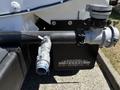 Close-up of a 2019 Ford F-750 with visible plumbing components including a hose connection and a valve attached to the vehicle's chassis