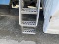 Metal step ladder attached to the side of a 2009 Dodge Ram 5500 with three perforated steps for access to the vehicle's cab