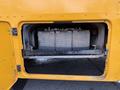 A yellow 2022 Freightliner B2 with an open access panel revealing stacked batteries inside a compartment