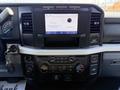 Dashboard of a 2023 Ford F-550 featuring a touchscreen display with audio information and various controls for climate and media settings