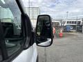 A 2023 Ford Transit van with a focus on its side mirror and part of the door showing the vehicle's sleek design and structure