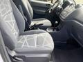 Interior of a 2010 Ford Transit Connect showing two front seats with geometric-patterned fabric and a dashboard with controls and gear shift