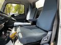 Interior of a 2015 Mitsubishi Fuso FE showing two blue cloth seats with adjustable features and a steering wheel in the foreground