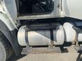A 2014 International 7400 truck fuel tank secured with metal straps resting on steps next to the driver's side door