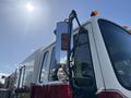 A 1994 Volvo FE 42 fire truck with a shiny chrome side mirror and an amber light mounted above the windshield