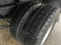 A close-up view of two wet dual tires mounted on a GMC C5 Duramax showing deep treads and a rugged design for heavy-duty performance