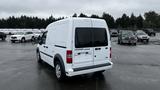 A white 2012 Ford Transit van is parked with its rear view visible showcasing dual rear doors and a sleek design