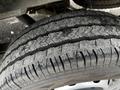 A close-up of a worn tire from a 2021 Ford Transit showing visible tread patterns and dirt accumulation