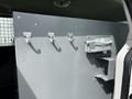 A 2011 Dodge Grand Caravan interior with a gray wall feature equipped with four hooks and a small mounted storage box
