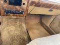 The interior of a 1982 Mercury Grand Marquis featuring a wood grain dashboard a vintage radio and beige carpeted floor mats