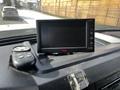 A 2011 Ford F-450 SD dashboard featuring a black monitor and remote control placed on the console