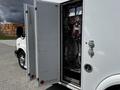 A 2013 Chevrolet Express with open doors revealing internal electrical and mechanical components