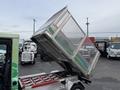 A 2019 CanEV Might-E Truck with its dump bed raised, showcasing the metal mesh structure and colorful design along the side